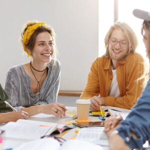 Kuvassa ihmisiä pöydän ympärillä ja pöydällä suunnittelupapereita.