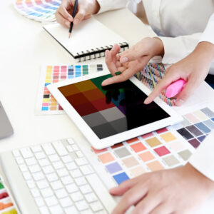 Kuvassa suunnittelupöytä, jossa värimalleja sekä tehdään muistiinpanoja.