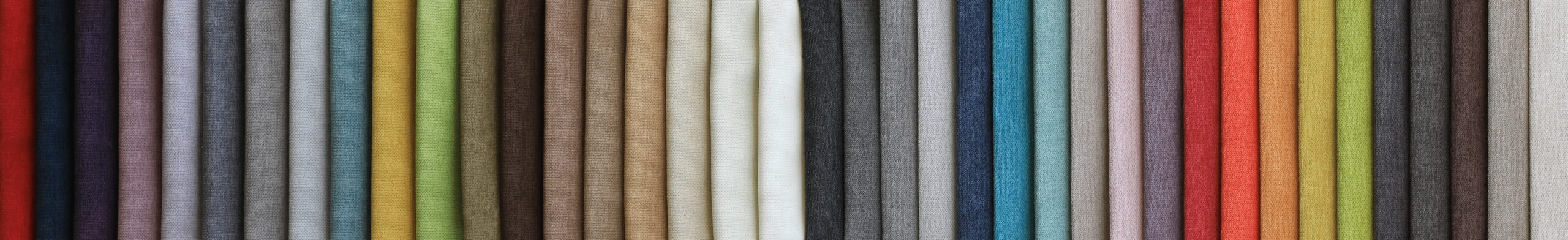 Värikkäitä kangasmalleja asetettuna riviin.